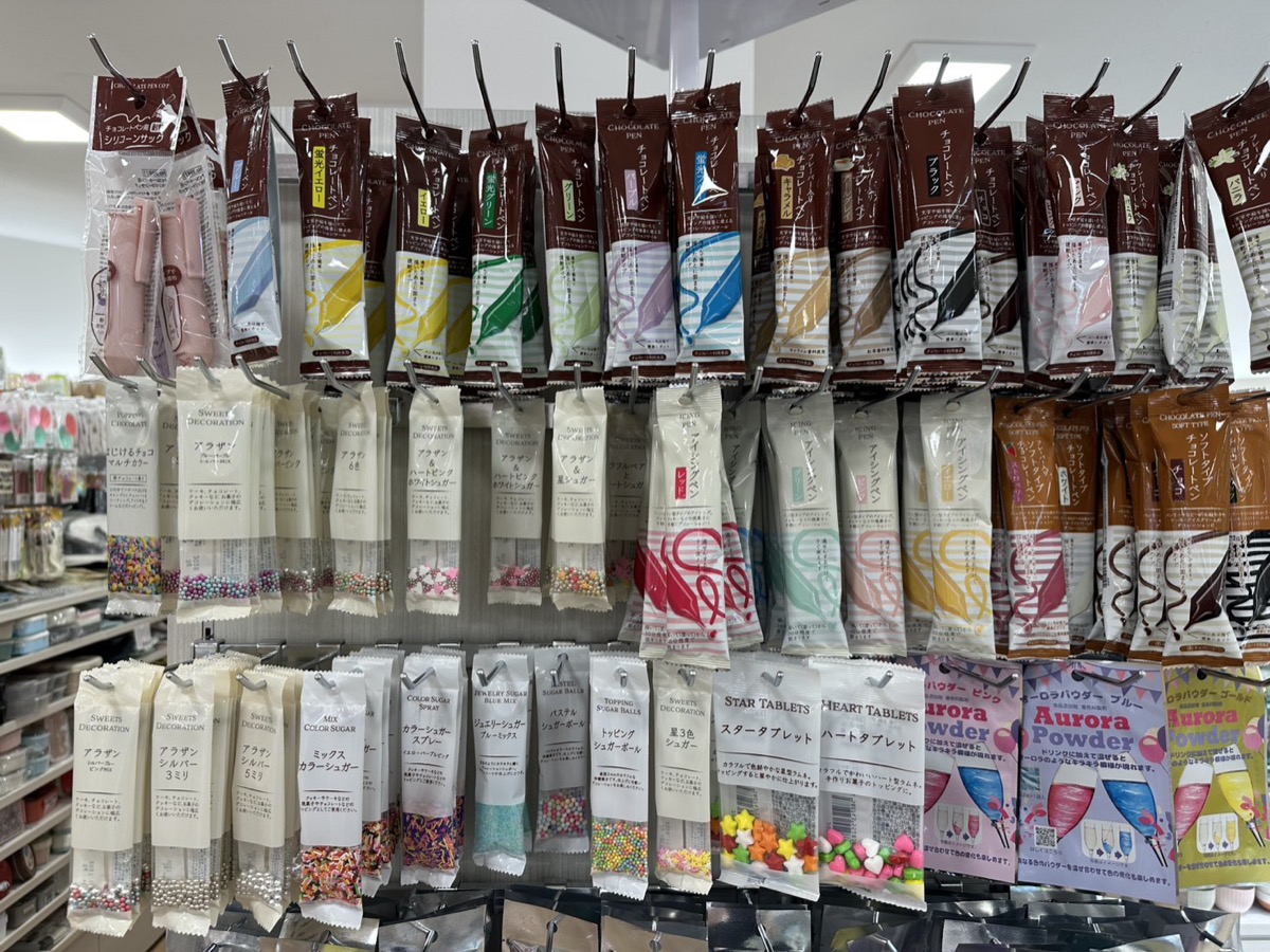 セリアのデコレーション素材売り場 — チョコペンやスプリンクルが並んでいる
